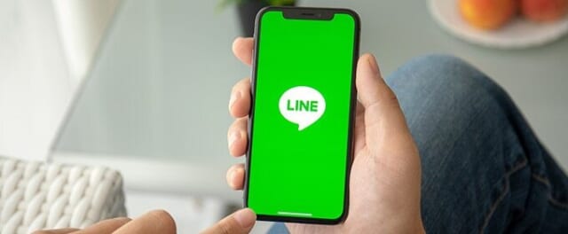 スマホのLINEを見ている男性