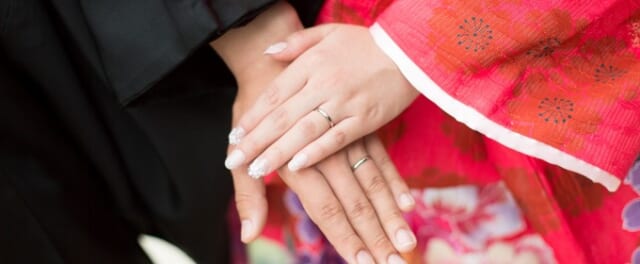 神社で結婚式した男女の手