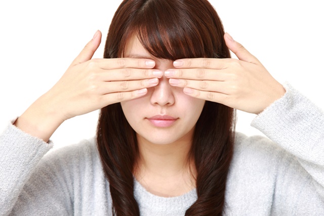 顔を隠している女性