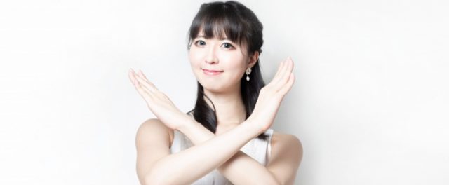 腕でバツマークを作る女性の画像