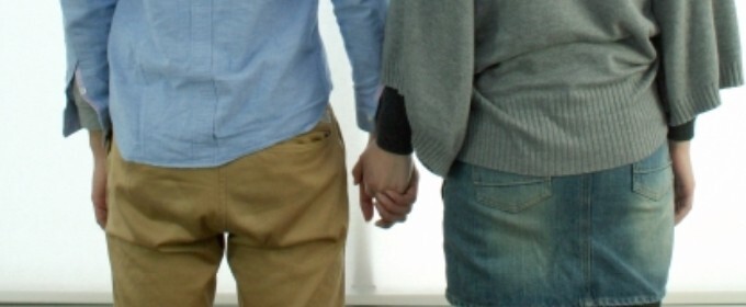 手を繋ぐカップルの後ろ姿